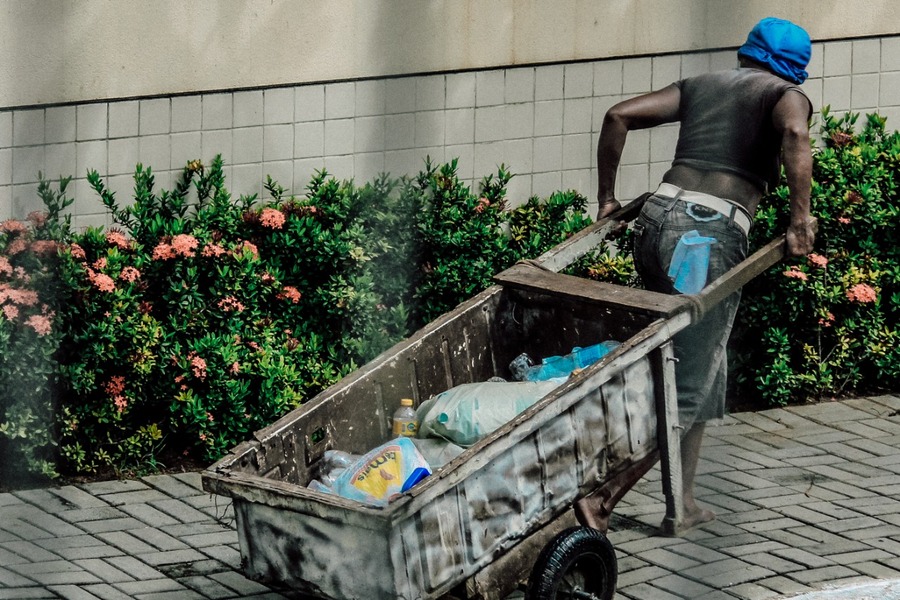 Homem em situação de rua, puxa uma carroça