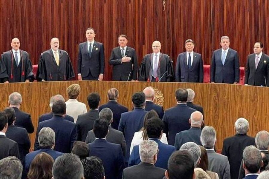 Foto em que se vê de frente, os integrantes que participaram da mesa em que Alexandre de Moraes tomou posse no TSE. Em frente, o público que está de costas a quem vê a fotografia