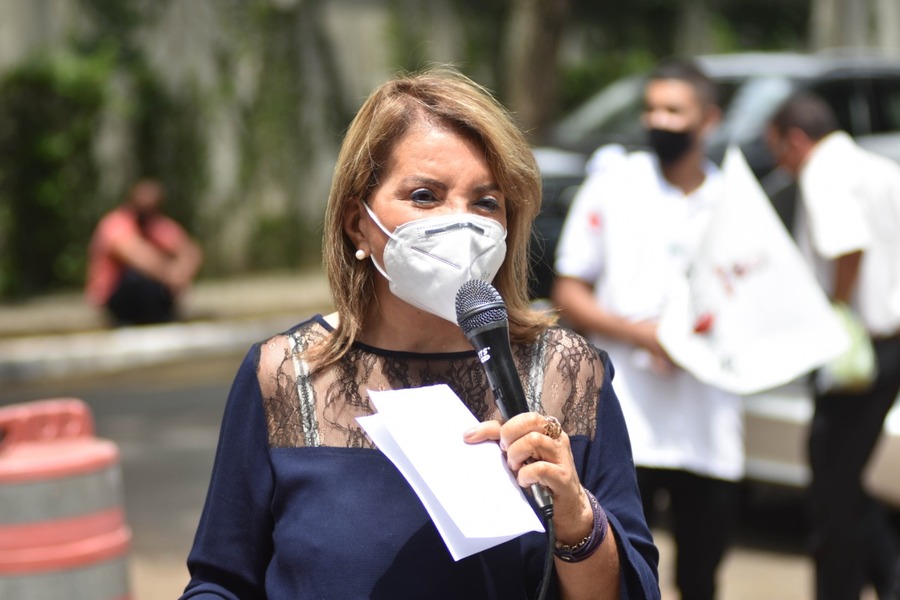 Foto da Deputada Estadual Professora Bebel falando ao microfone em ato público