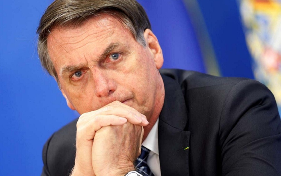 Foto em close de bolsonaro apoiando as mãos no queixo com os olhos mareados