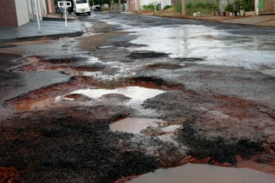 Foto de uma rua cheia de buracos