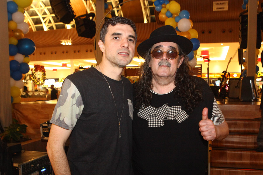 Foto de Davi Moraes e Moraes Moreira, um ao lado do outro. Moraes Moreira faz um "joinha" com a mão esquerda