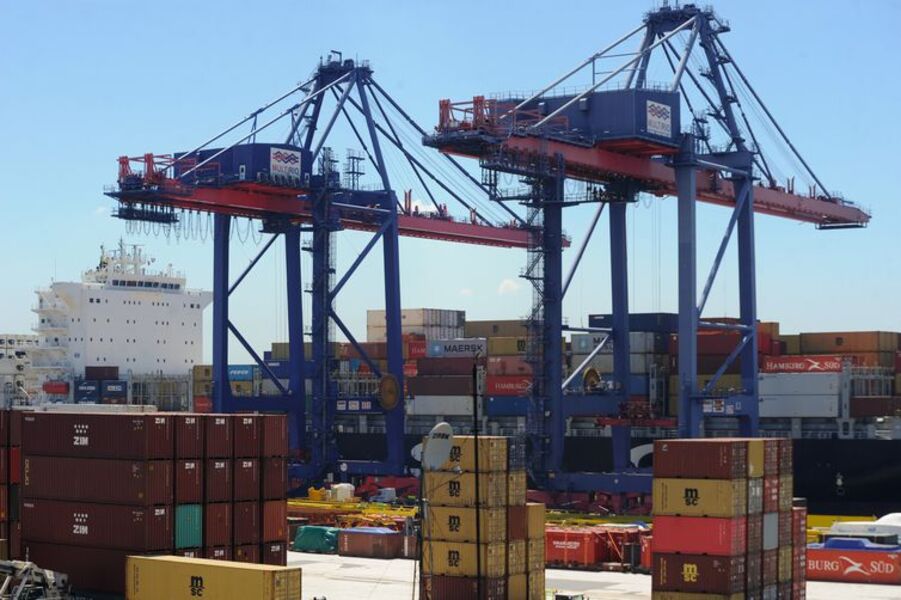 Foto de guindastes carregando conatainers de mercadorias para o navio