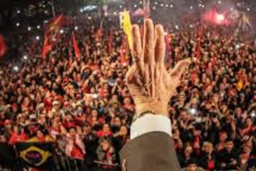 Lula, num comício lotado, estende o braço e a foto pega apenas o antebraço e a mão esquerda dele