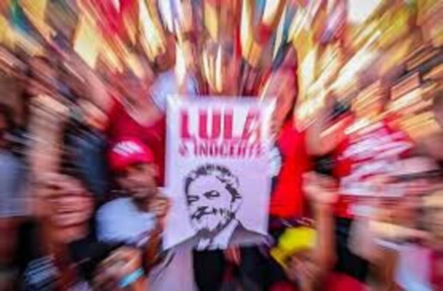 Homem segura cartaz escrito Lula Inocente. A foto está sob efeito de zoom