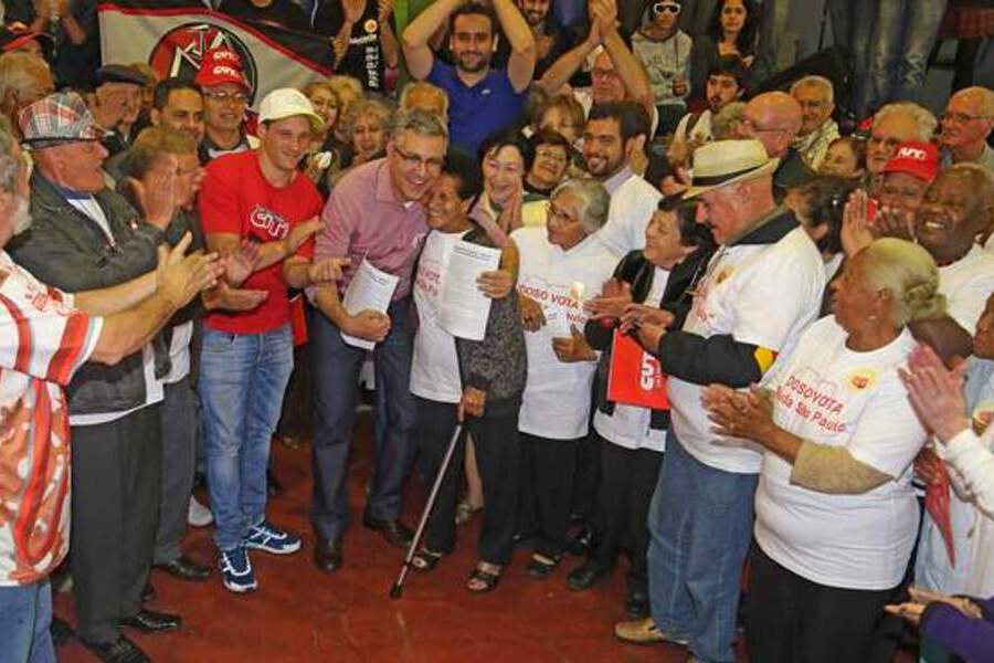 Deputado Federal Alexandre Padilha abraça idosa em meio a vários manifestantes de mais idade