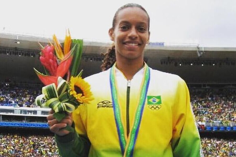 Foto da medalhista Rosana exibindo sua medalhe e um buque de flores