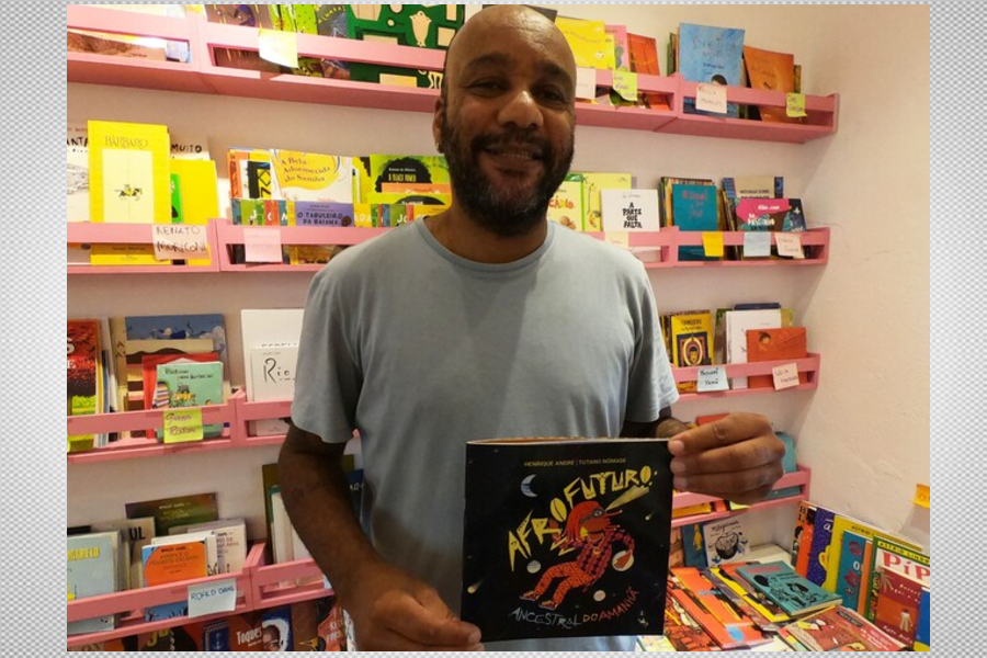 foto do escritor Henrique André exibindo seu livro premiado