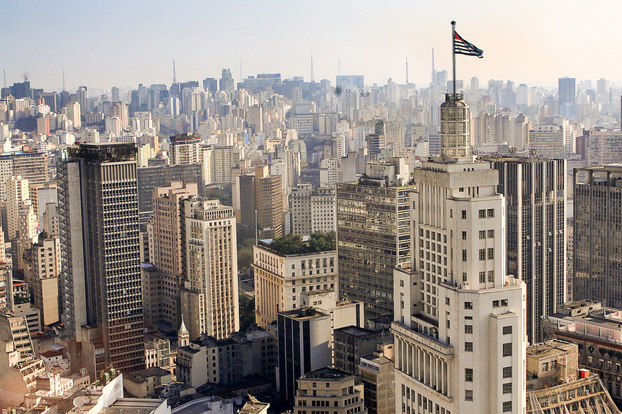 Vista parcial e aérea do centro de São Paulo, focando o prédio do Bradesco com a bandeira paulista tremulando