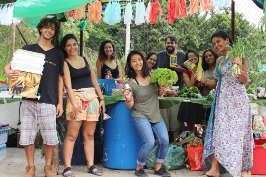 Grupo de pessoas, em frente a uma barraca de produtos orgânicos, posam para foto. São as pessoas que compõem o Autonomia ZN