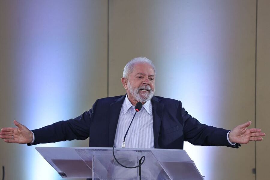 Foto de Lula durante a entrevista coletiva à mídia independente, dia 19 de janeiro, em São Paulo. Lula está de braços abertos falando ao microfone