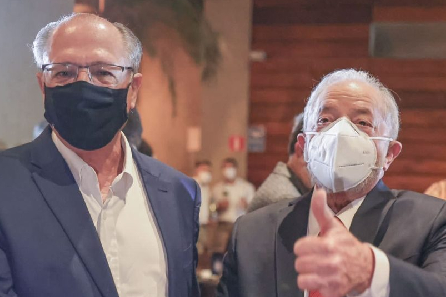 Foto de Alckmin (à esq.) e Lula (à dir). Ambos olham para o leitor. Lula está com o polegar pra cima indicando sinal de "ok".