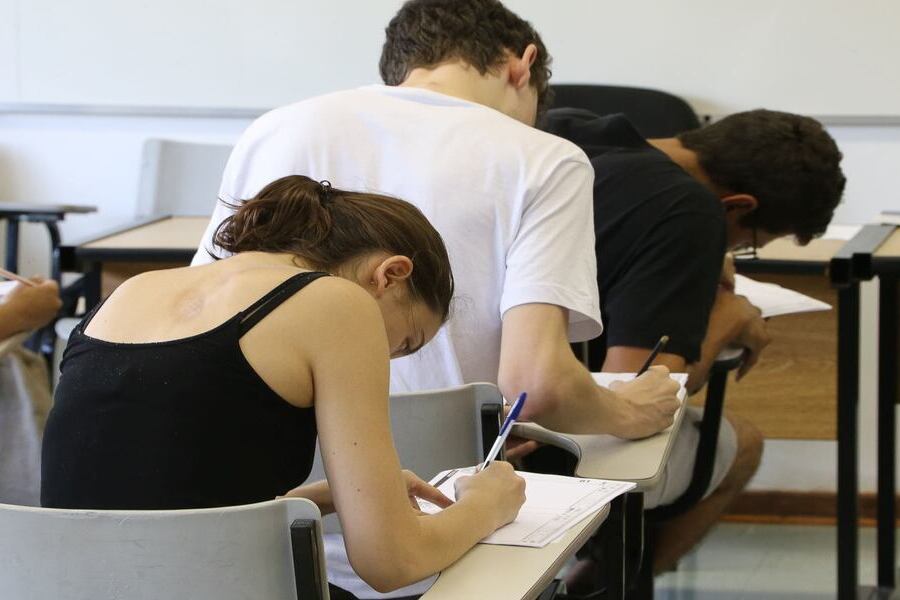 Pessoas fazendo aula são fotografadas por trás em suas respectivas cadeiras