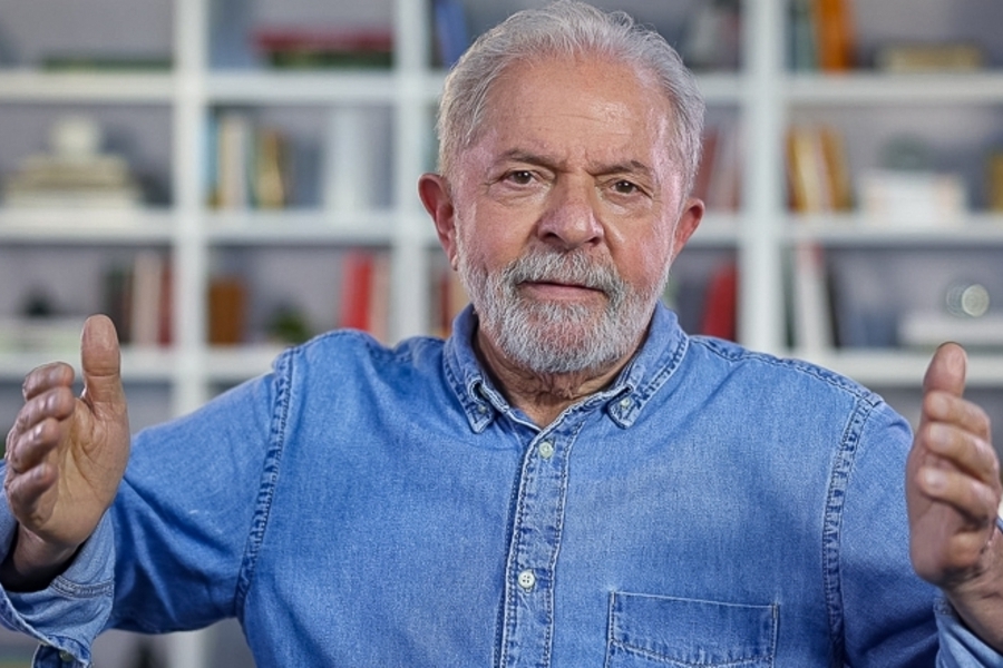 Foto de Lula com os braços abertos e com camisa jeans