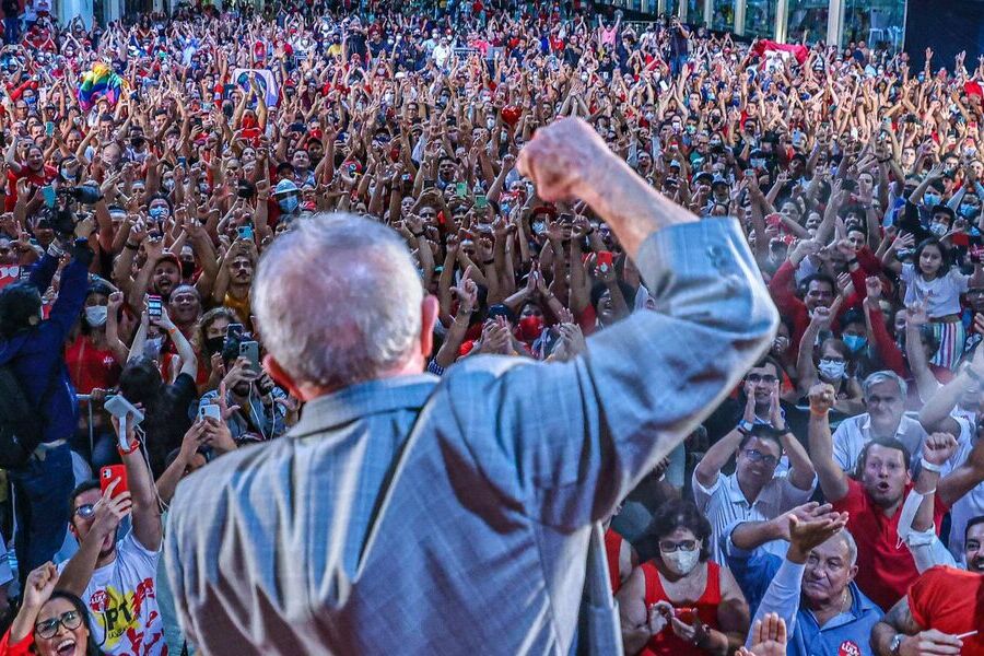 Foto de Lula, de frente para a multidão, comemora como se tivesse marcado um gol