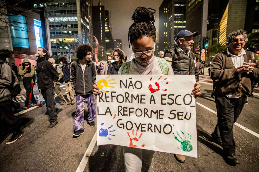 Aluna do ensino médio exibe cartaz contra a reforma do ensino