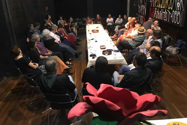 Foto de muitas pessoas sentadas em volta de uma mesa